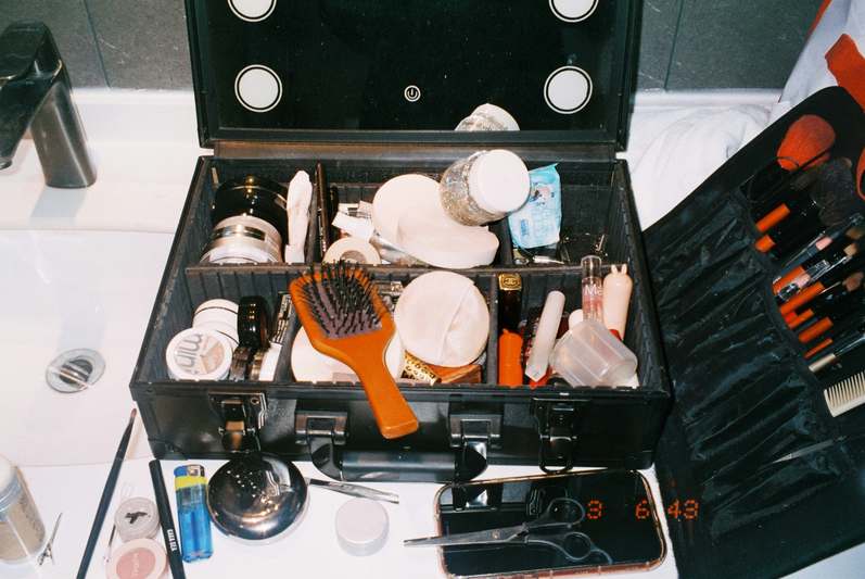 Woman smiling while organizing makeup in a sleek, modern drawer unit